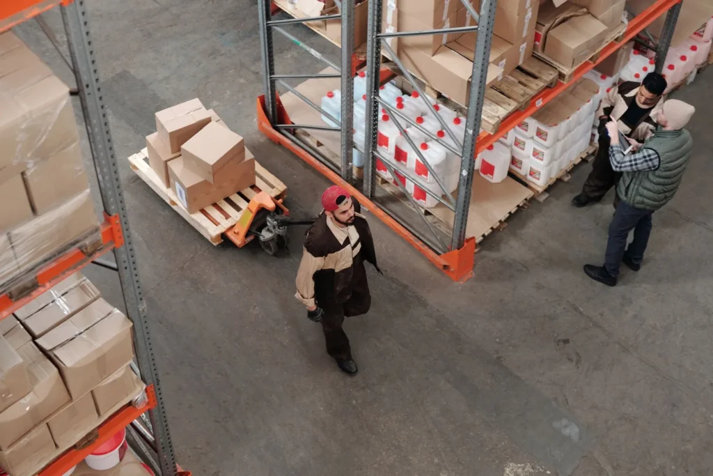 Warehouse workers moving palletized stock through a pharmaceutical distribution facility