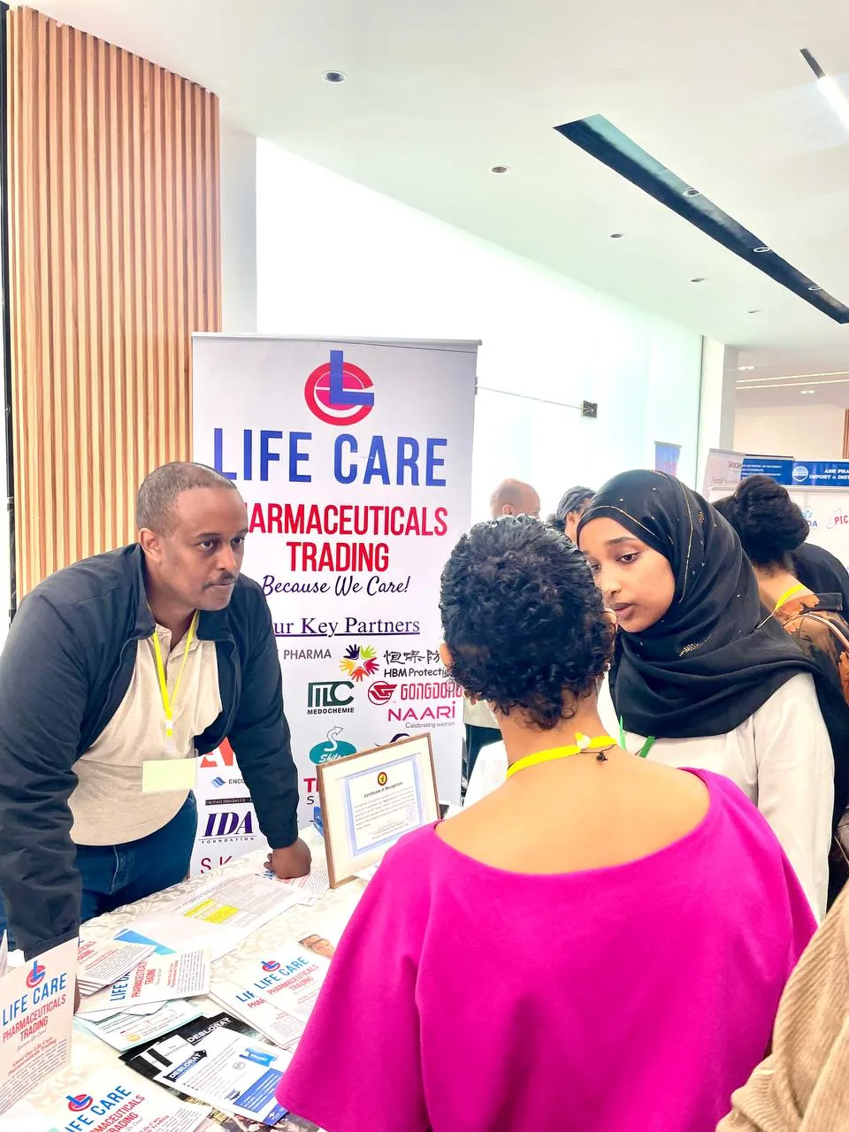 Delegates in discussion at the LifeCare stand LifeCare team member discussing products with two conference delegates at the exhibition stand